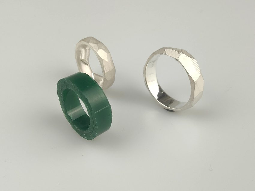 Ringwachsrohling, neben gegossenem Ring in Silber, neben gefinishtem Silberring